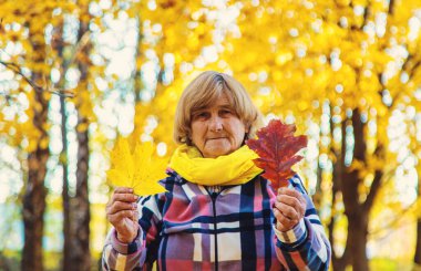 Sonbahar parkında kıdemli bir kadın. Seçici odaklanma. Doğa.