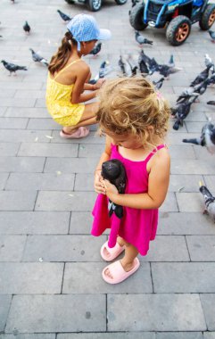 Bir çocuk parkta güvercin kovalıyor. Seçici odaklanma. Çocuk.