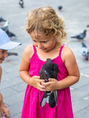 Bir çocuk parkta güvercin kovalıyor. Seçici odaklanma. Çocuk.