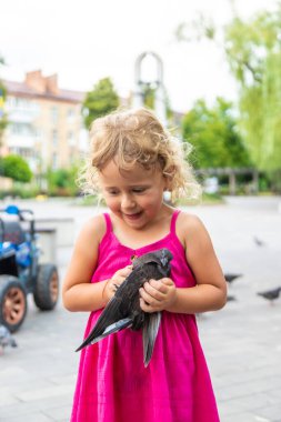 Bir çocuk parkta güvercin kovalıyor. Seçici odaklanma. Çocuk.