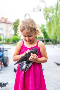 Bir çocuk parkta güvercin kovalıyor. Seçici odaklanma. Çocuk.