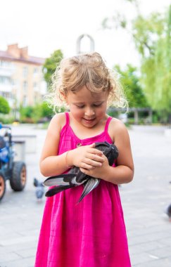 Bir çocuk parkta güvercin kovalıyor. Seçici odaklanma. Çocuk.