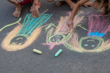 Çocuklar asfalta tebeşirle çizer. Seçici odaklanma. çocuk.