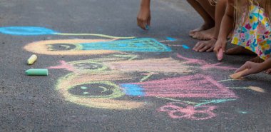 Çocuklar asfalta tebeşirle çizer. Seçici odaklanma. çocuk.