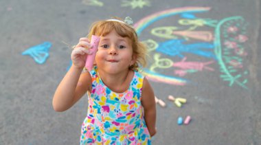 Çocuklar asfalta tebeşirle çizer. Seçici odaklanma. çocuk.
