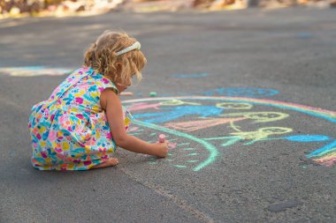 Çocuklar asfalta tebeşirle çizer. Seçici odaklanma. çocuk.