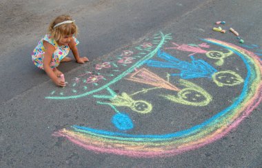 Çocuklar asfalta tebeşirle çizer. Seçici odaklanma. çocuk.