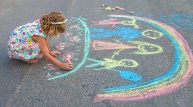 Çocuklar asfalta tebeşirle çizer. Seçici odaklanma. çocuk.