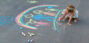 Çocuklar asfalta tebeşirle çizer. Seçici odaklanma. çocuk.