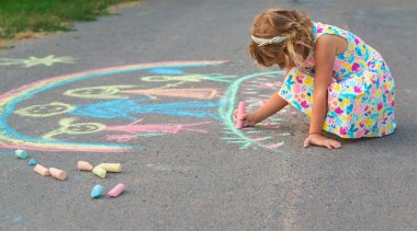 Çocuklar asfalta tebeşirle çizer. Seçici odaklanma. çocuk.