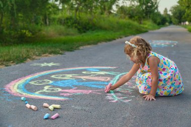 Çocuklar asfalta tebeşirle çizer. Seçici odaklanma. çocuk.