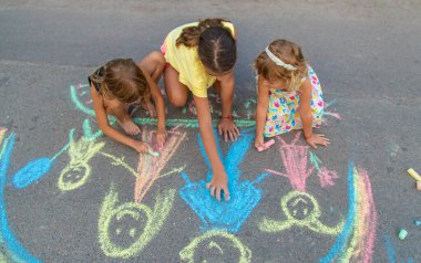 Çocuklar asfalta tebeşirle çizer. Seçici odaklanma. çocuk.
