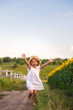 Bir çocuk köydeki bir tarladan koşarak geçiyor. Seçici odaklanma. Çocuk.