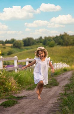Bir çocuk köydeki bir tarladan koşarak geçiyor. Seçici odaklanma. Çocuk.
