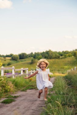 Bir çocuk köydeki bir tarladan koşarak geçiyor. Seçici odaklanma. Çocuk.