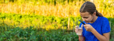 Bir çocuk büyüteçle suya bakar. Seçici odaklanma. çocuk.