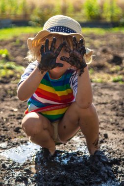 Çamurda oynayan çocuk. Seçici odaklanma. Çocuk.