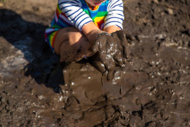 Çamurda oynayan çocuk. Seçici odaklanma. Çocuk.