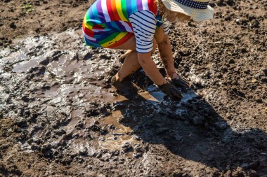 Çamurda oynayan çocuk. Seçici odaklanma. Çocuk.