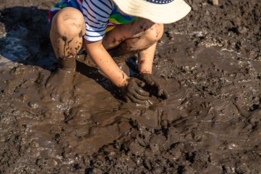 Çamurda oynayan çocuk. Seçici odaklanma. Çocuk.