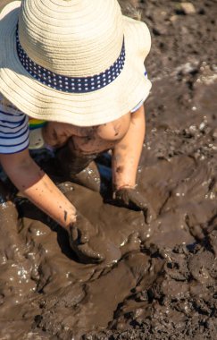 Çamurda oynayan çocuk. Seçici odaklanma. Çocuk.