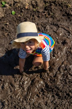 Çamurda oynayan çocuk. Seçici odaklanma. Çocuk.