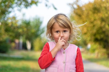 Bir çocuk parmağıyla burnunu karıştırıyor. Seçici odaklanma. çocuk.