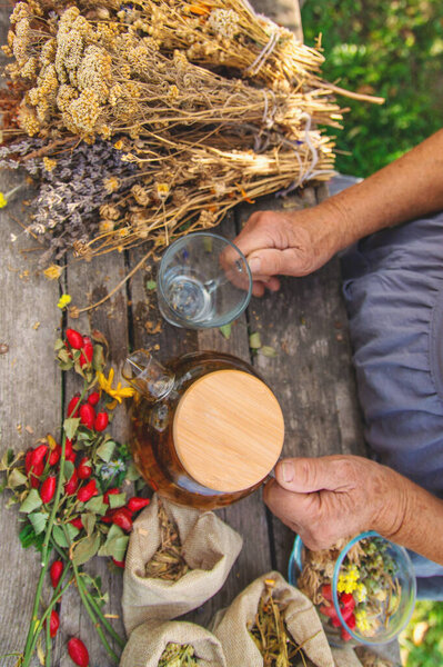 Medicinal herbs and tea old woman. Selective focus. Nature.