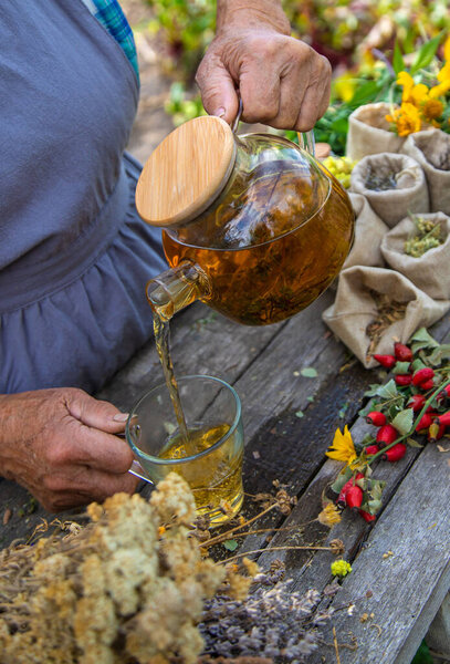 Medicinal herbs and tea old woman. Selective focus. Nature.