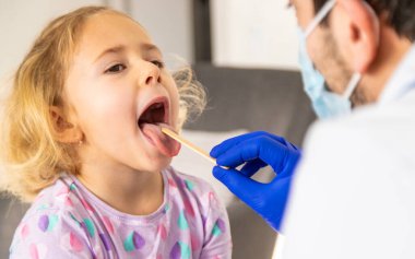 Klinikte bir çocuk bir doktor tarafından tedavi ediliyor. Seçici odaklanma. Çocuk.