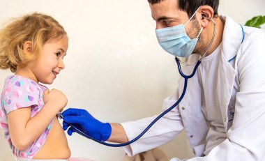 Klinikte bir çocuk bir doktor tarafından tedavi ediliyor. Seçici odaklanma. Çocuk.