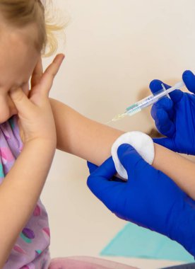 Bir doktor tarafından tedavi edilen çocuk aşı oluyor. Seçici odaklanma. Çocuk.