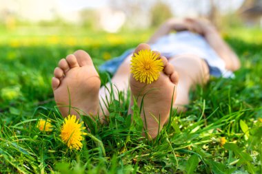 Karahindiba bahçesinde çocuk ayakları. Seçici odaklanma. çocuk,