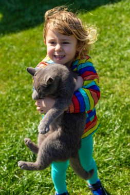 Sokakta kediye sarılan bir çocuk. Seçici odaklanma. çocuk.