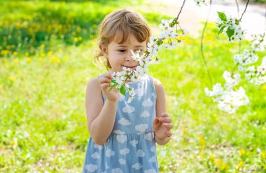 Çiçek açan ağaçların bahçesindeki bir çocuk. Seçici odaklanma. çocuk.