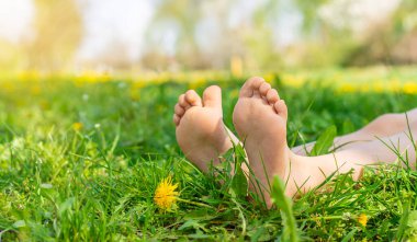 Karahindiba bahçesinde çocuk ayakları. Seçici odaklanma. çocuk,