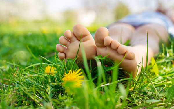 детские ноги в саду с одуванчиками. Выборочный фокус. ребенок,