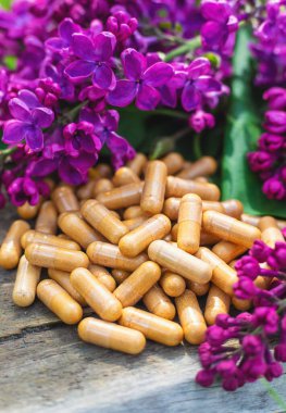 Leylak çiçeği özü ve diyet takviyeleri. Seçici odaklanma. Doğa. kapsüller,