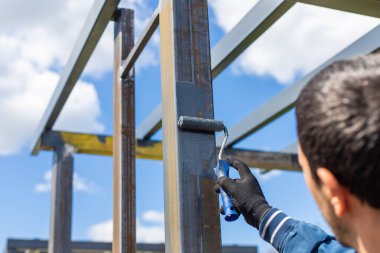 Metal direkleri boyayan adam. Seçici odaklanma. Doğa.