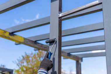 Metal direkleri boyayan adam. Seçici odaklanma. Doğa.