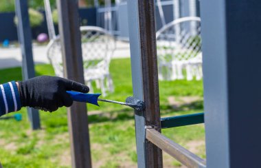 Metal direkleri boyayan adam. Seçici odaklanma. Doğa.
