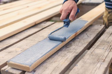 Bir adam bir tahtayı boyayla boyuyor. Seçici odaklanma. İnsanlar.