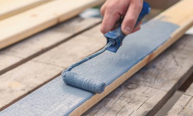 Bir adam bir tahtayı boyayla boyuyor. Seçici odaklanma. İnsanlar.