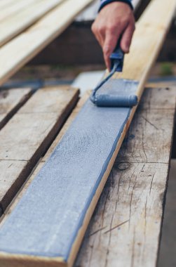 Bir adam bir tahtayı boyayla boyuyor. Seçici odaklanma. İnsanlar.