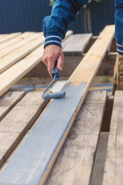 Bir adam bir tahtayı boyayla boyuyor. Seçici odaklanma. İnsanlar.