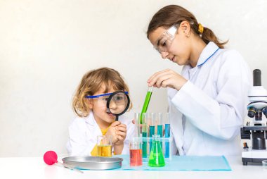 Test tüpleri, reaktörleri ve mikroskobu olan bir çocuğun laboratuvar incelemesi. Seçici odaklanma. çocuk.