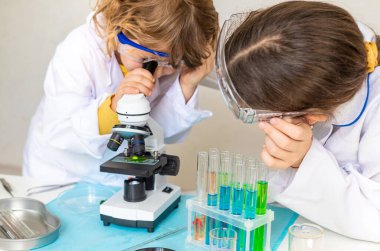 Test tüpleri, reaktörleri ve mikroskobu olan bir çocuğun laboratuvar incelemesi. Seçici odaklanma. çocuk.