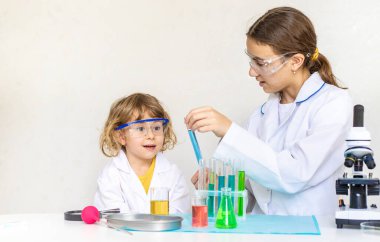 Test tüpleri, reaktörleri ve mikroskobu olan bir çocuğun laboratuvar incelemesi. Seçici odaklanma. çocuk.