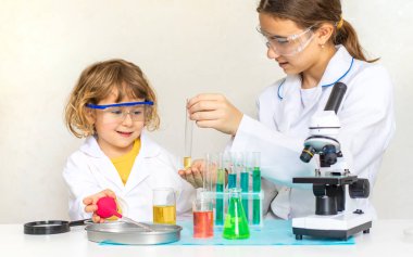 Test tüpleri, reaktörleri ve mikroskobu olan bir çocuğun laboratuvar incelemesi. Seçici odaklanma. çocuk.