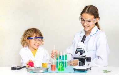 Test tüpleri, reaktörleri ve mikroskobu olan bir çocuğun laboratuvar incelemesi. Seçici odaklanma. çocuk.